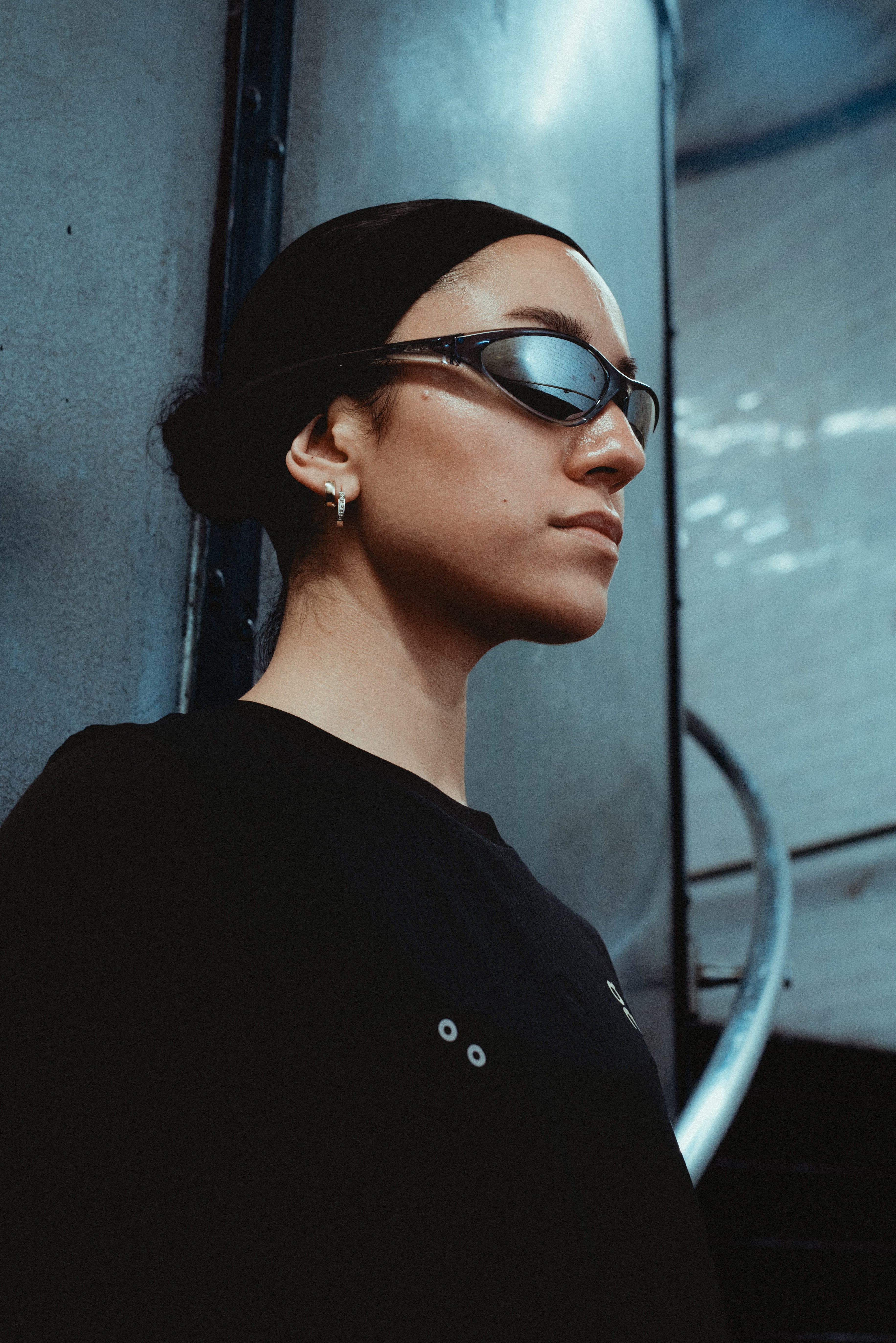 Person wearing sunglasses and a black top in an urban setting