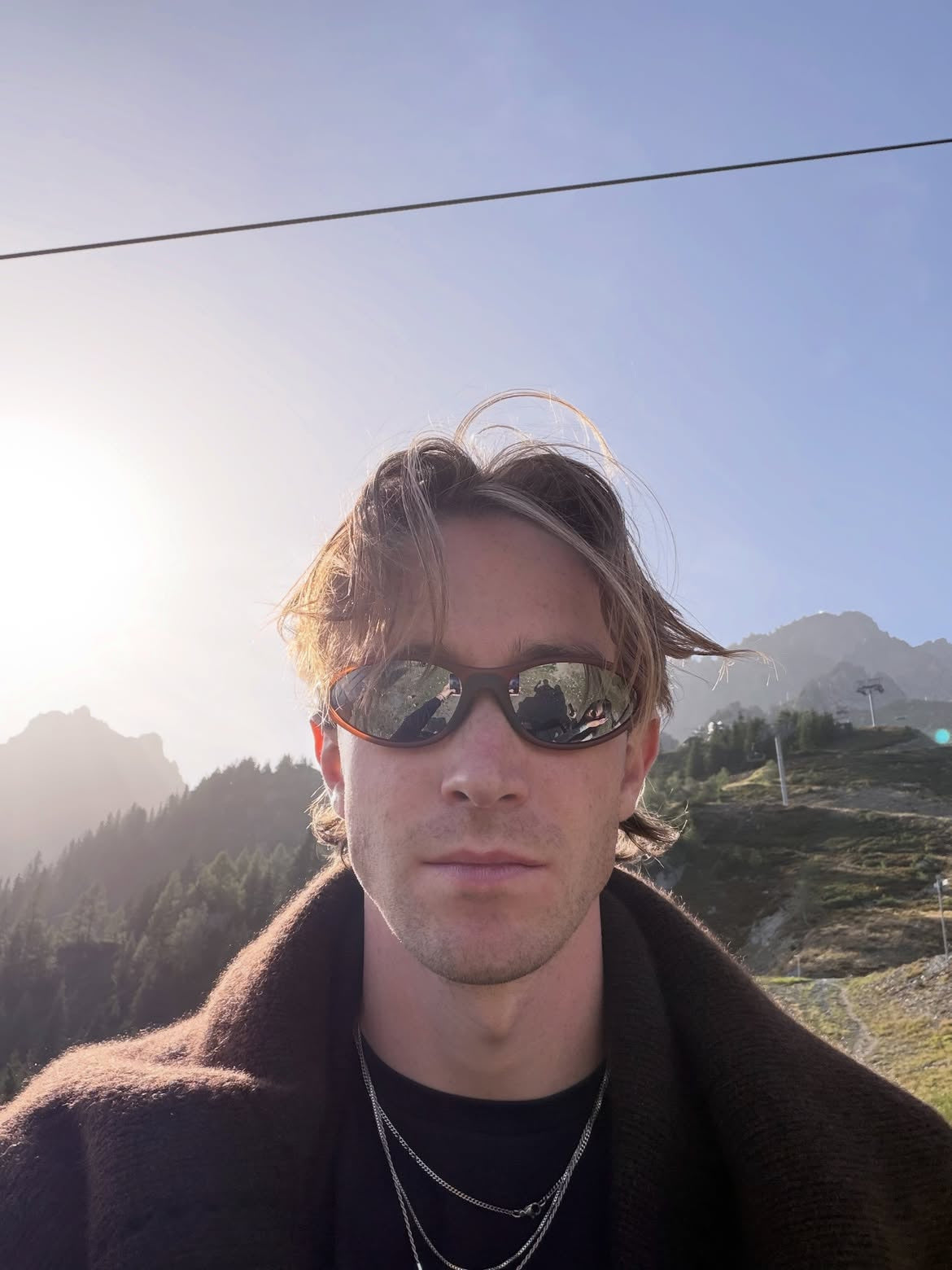Customer wearing AIM Earth sunglasses — mountain portrait