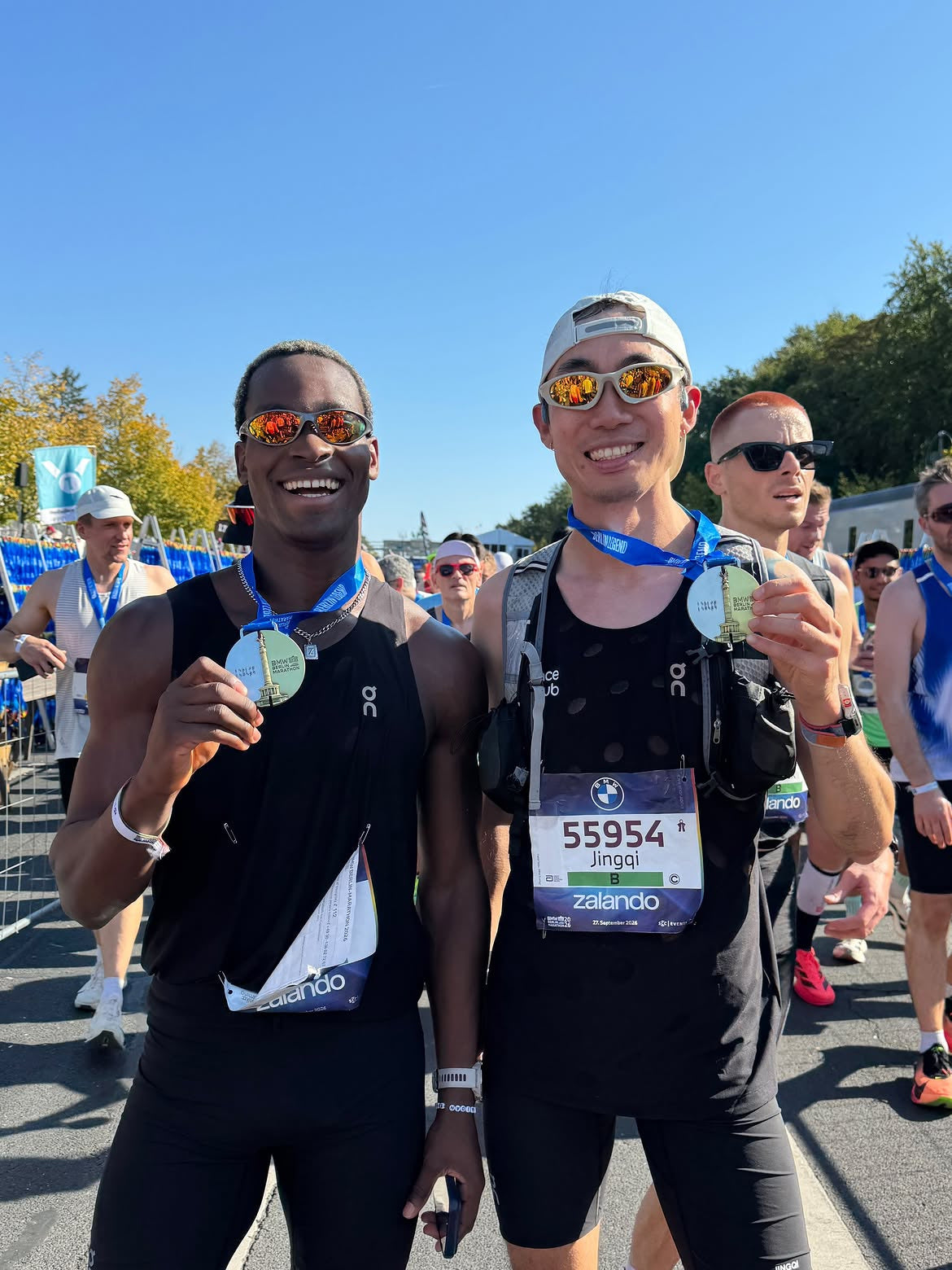 Customer wearing AIM Gunmetal sunglasses — post-race portrait with friends