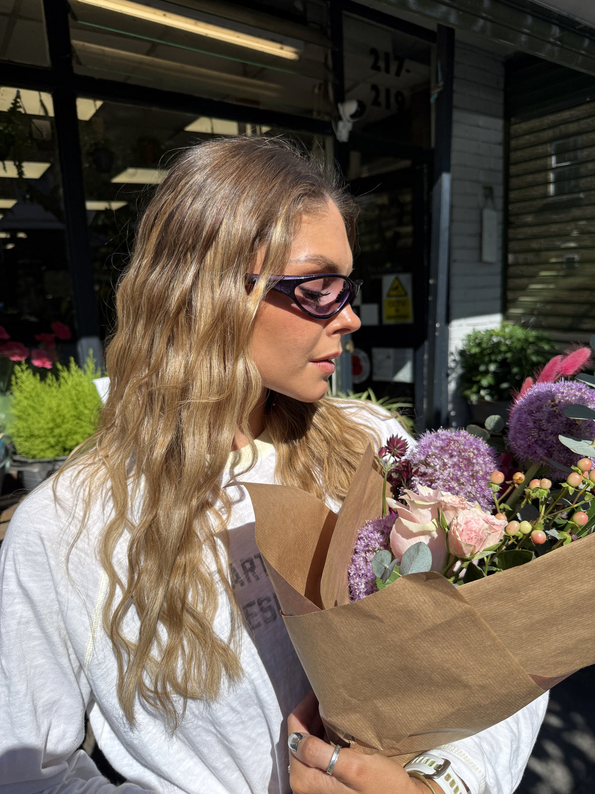 Customer wearing AIM Lavender sunglasses — flower-shop portrait