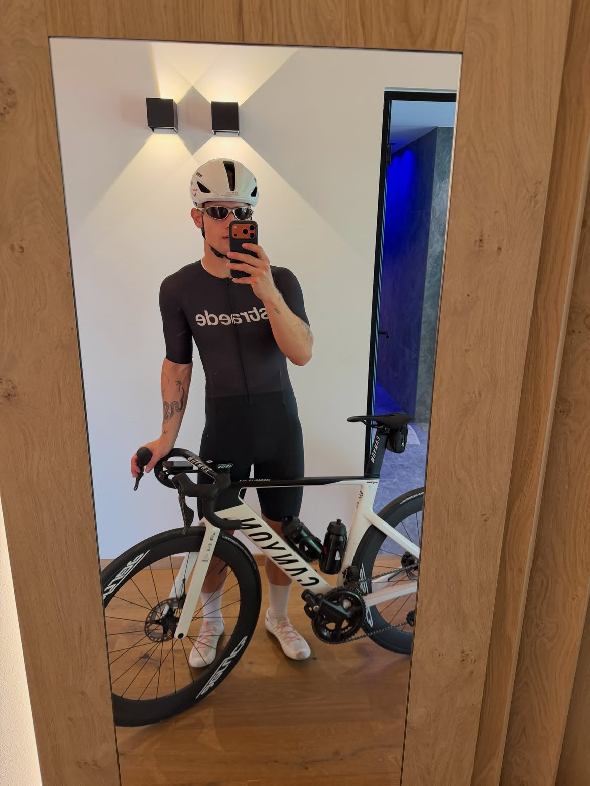Customer wearing AIM London Gold sunglasses — cycling mirror portrait
