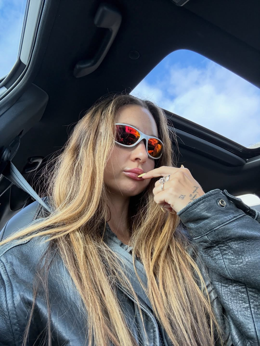 Customer wearing AIM Pearl Heat sunglasses — passenger-seat portrait