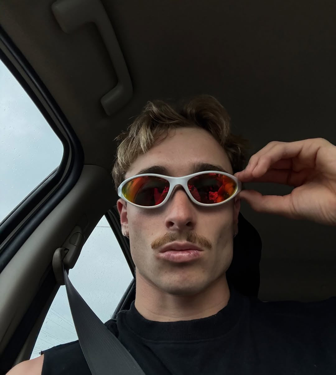 Customer wearing AIM Pearl Heat sunglasses — passenger-seat portrait