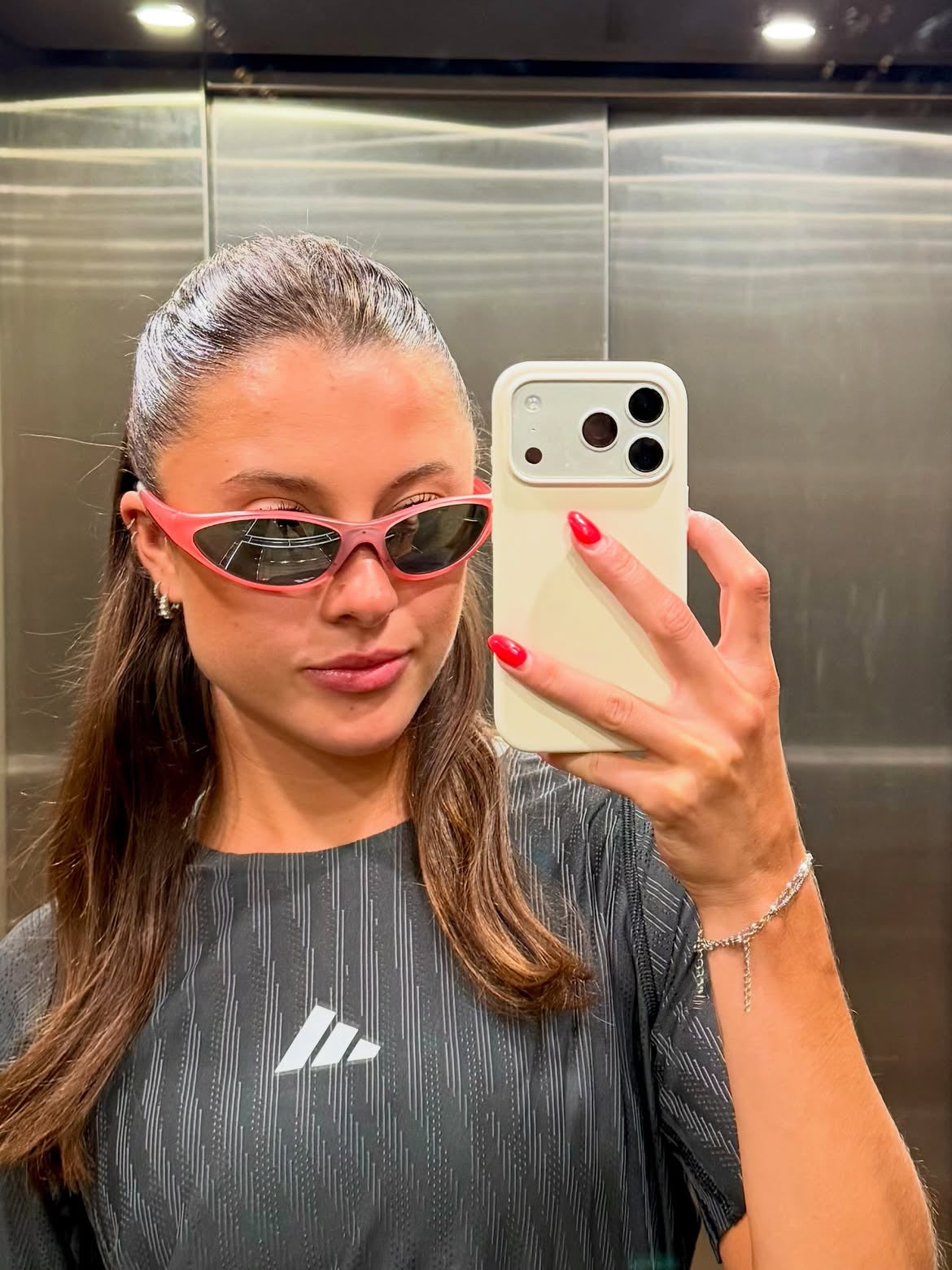 Customer wearing AIM Rose sunglasses — elevator mirror portrait